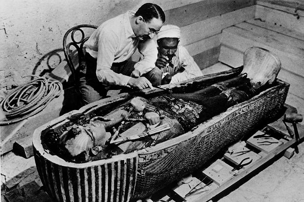 Carter e um trabalhador analisando um segundo sarcófago na parte interna formada por ouro maciço. 